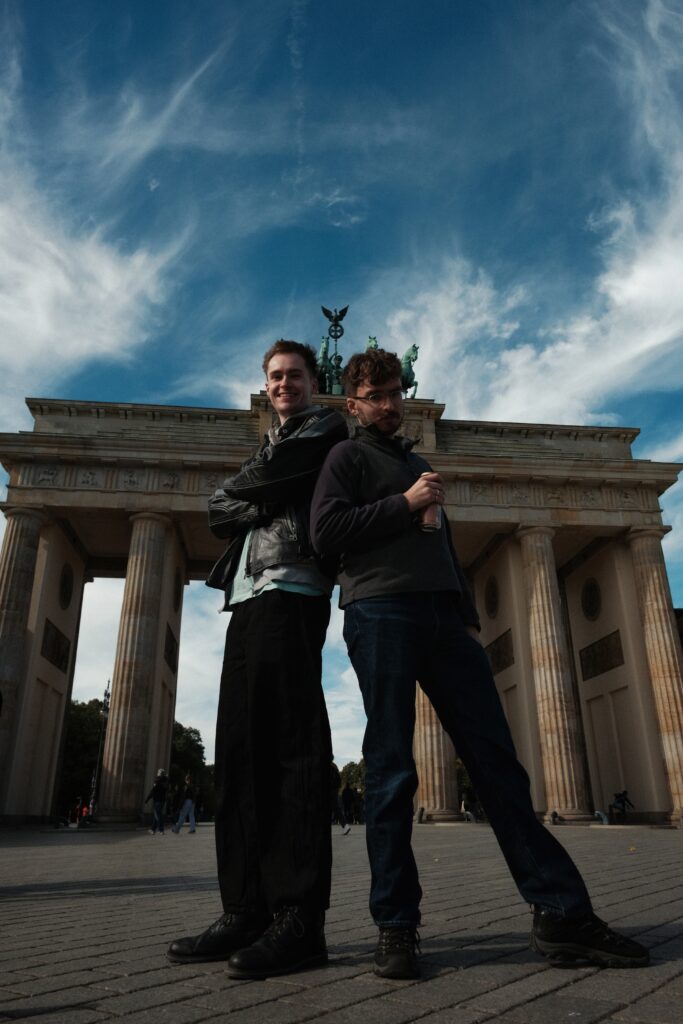 Two men standing back-to-back in front of the Brandenburg gate, shot on Fujifilm X-T2