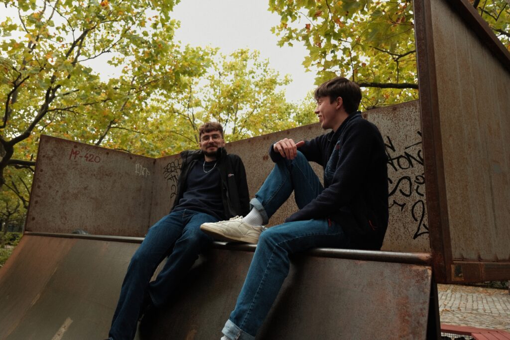 Candid street photography of two young men in conversation in a skatepark in Berlin, shot on Fujifilm X-T2